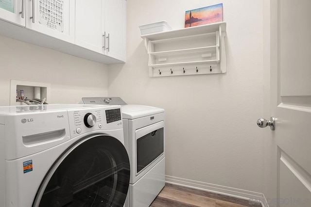 laundry area with cabinets, dark hardwood / wood-style flooring, and independent washer and dryer