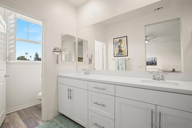 bathroom with toilet, ceiling fan, wood-type flooring, and vanity