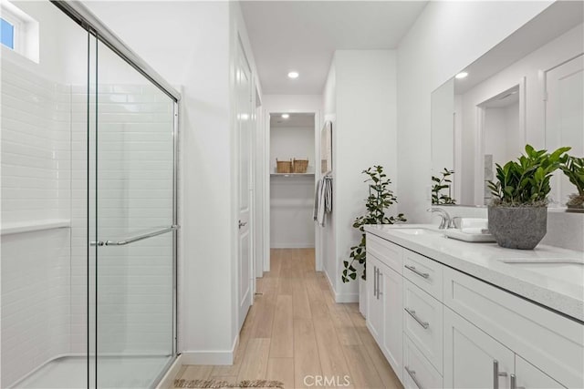 bathroom featuring an enclosed shower, vanity, and hardwood / wood-style flooring