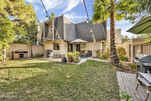 rear view of property with a lawn and a patio