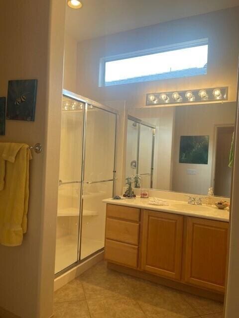 bathroom featuring walk in shower, vanity, and tile patterned flooring