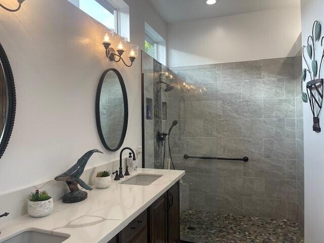 bathroom with tiled shower and vanity