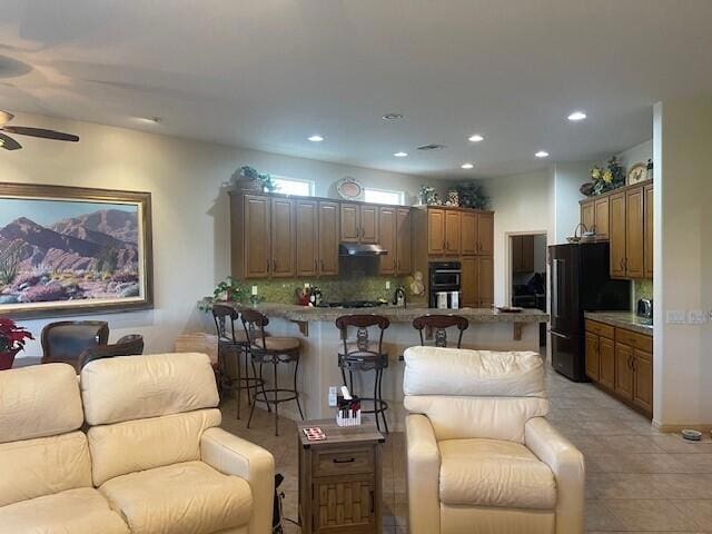 living room with ceiling fan and light tile patterned flooring