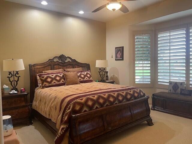 bedroom with ceiling fan and light colored carpet