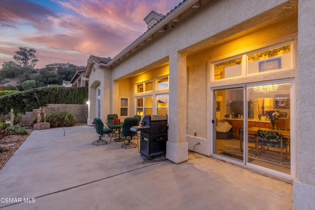 patio terrace at dusk featuring grilling area