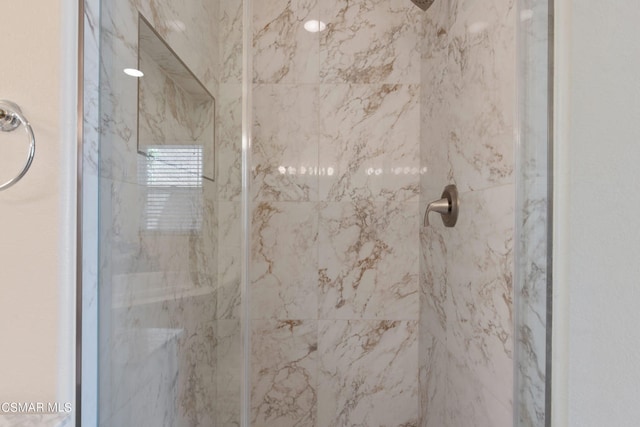 interior details featuring a tile shower