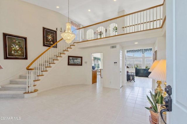 tiled foyer entrance with a high ceiling and a notable chandelier