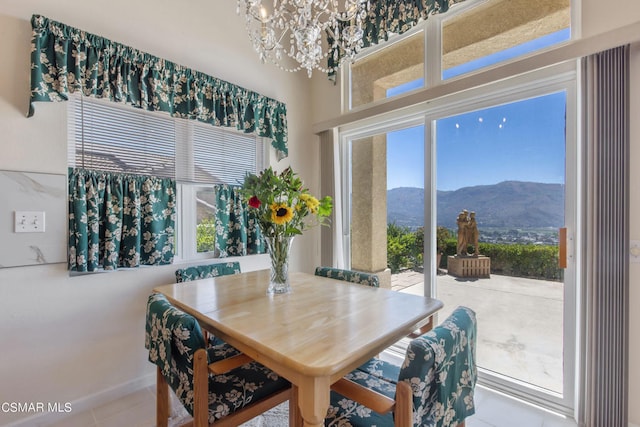 dining room with a mountain view, an inviting chandelier, and tile patterned flooring