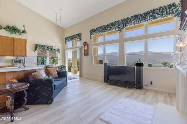 living room featuring a notable chandelier, sink, and light hardwood / wood-style floors