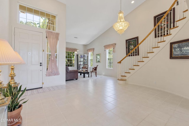 tiled entrance foyer with a high ceiling and a notable chandelier