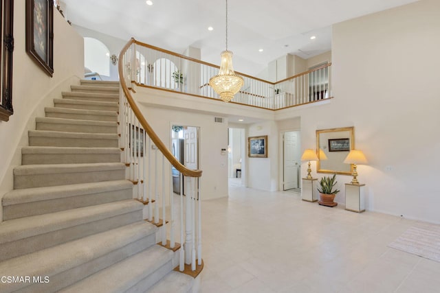 foyer with an inviting chandelier and a towering ceiling