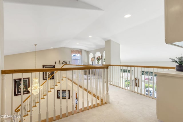 corridor featuring lofted ceiling, plenty of natural light, and carpet flooring