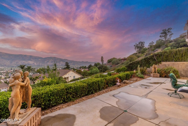 patio terrace at dusk featuring a mountain view