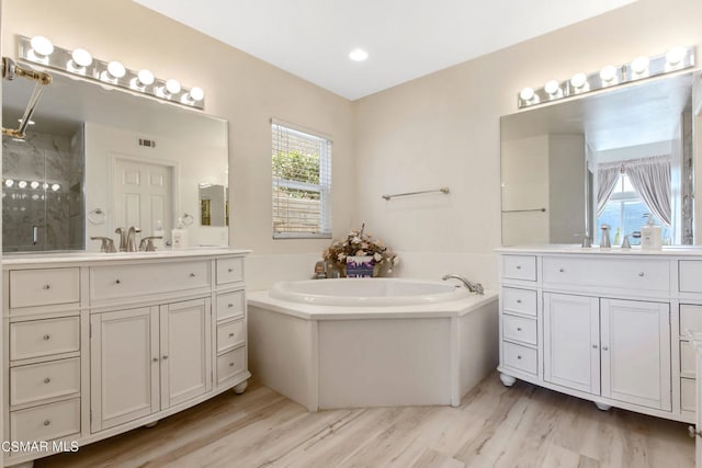 bathroom with vanity, wood-type flooring, and independent shower and bath