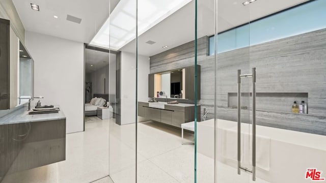 bathroom featuring a shower with door and vanity