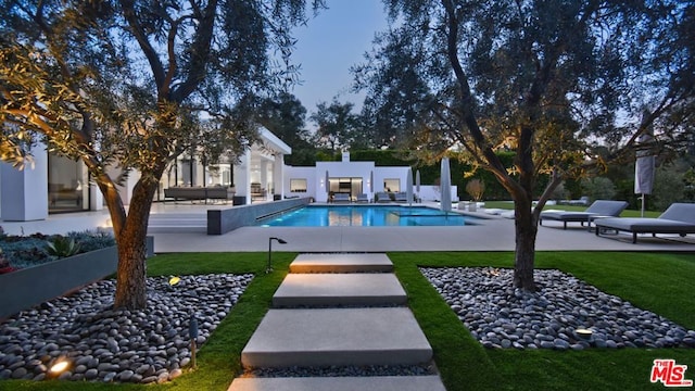 view of pool with a lawn and a patio