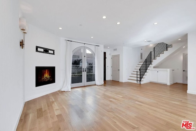 unfurnished living room with light hardwood / wood-style flooring and french doors