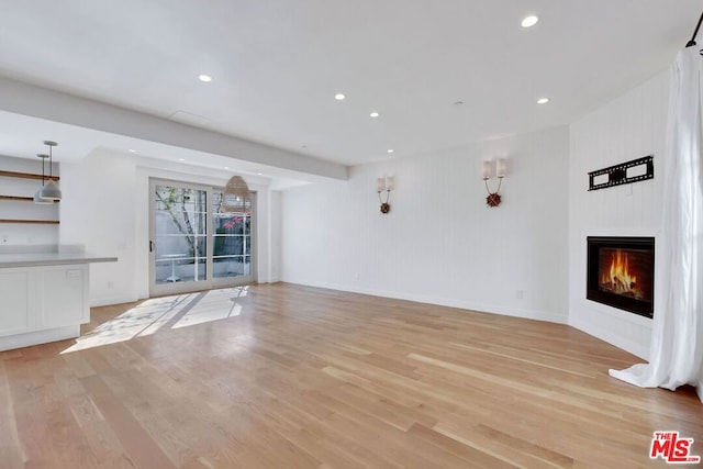 unfurnished living room with light hardwood / wood-style floors and a large fireplace