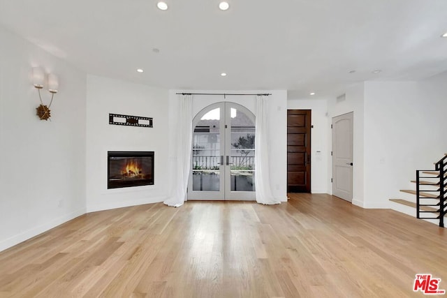 unfurnished living room with french doors and light hardwood / wood-style floors