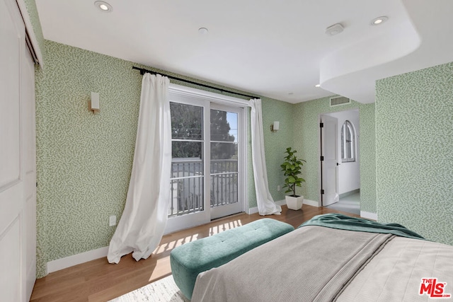 bedroom with wood-type flooring and access to outside