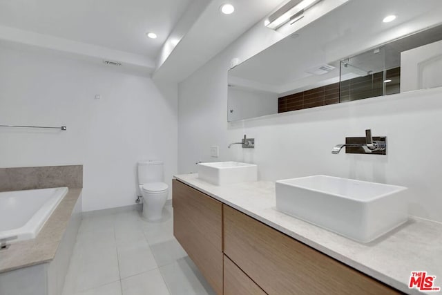 bathroom with tile patterned flooring, vanity, a washtub, and toilet