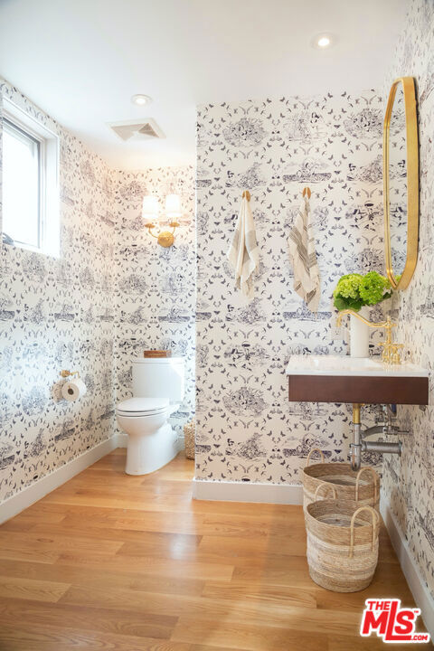 bathroom with toilet and hardwood / wood-style floors