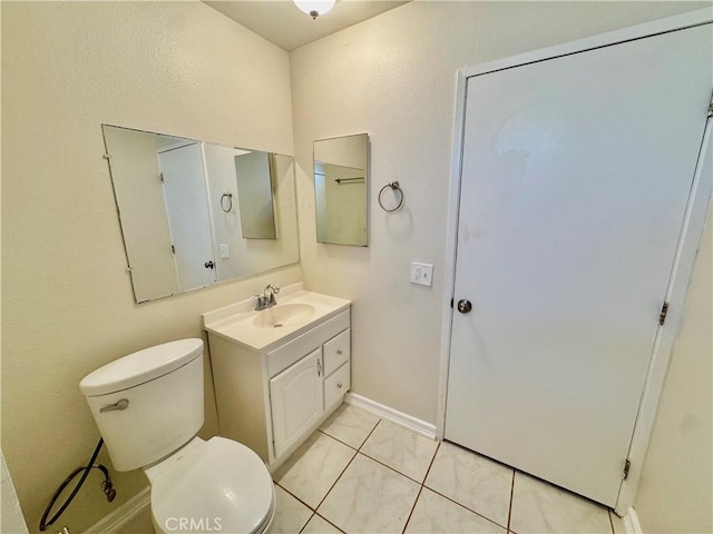 bathroom featuring toilet, vanity, and tile patterned flooring