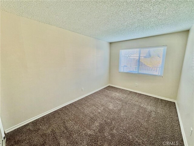 carpeted spare room with a textured ceiling