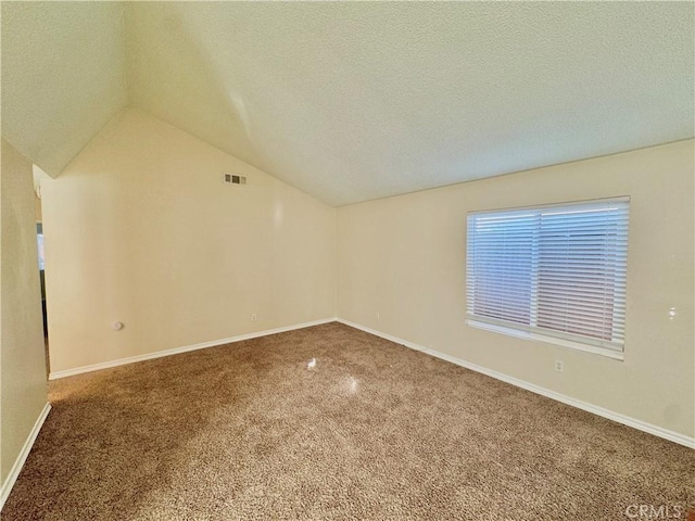 carpeted empty room with lofted ceiling and a textured ceiling