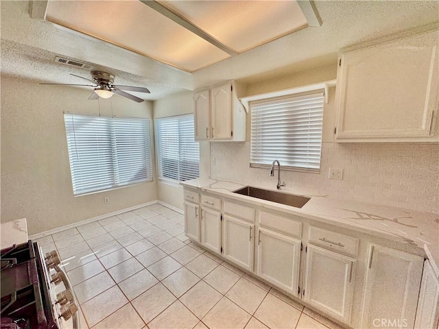 kitchen with ceiling fan, light tile patterned floors, tasteful backsplash, and sink