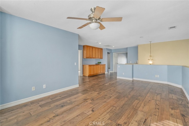 unfurnished living room with ceiling fan and wood-type flooring