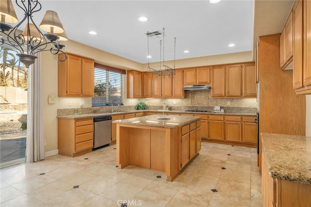 kitchen featuring stainless steel dishwasher, sink, pendant lighting, and a kitchen island