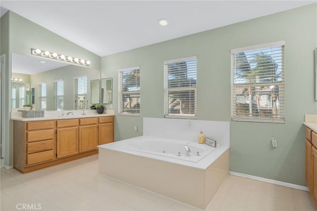 bathroom with a tub, vanity, and vaulted ceiling