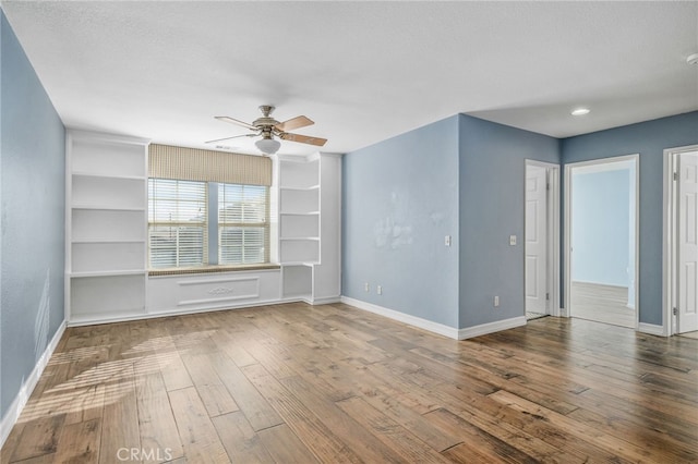 unfurnished living room featuring ceiling fan and hardwood / wood-style floors