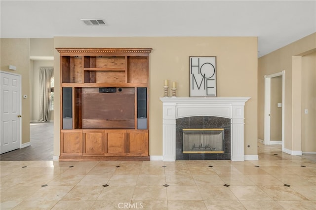 unfurnished living room featuring a tile fireplace and light tile patterned flooring