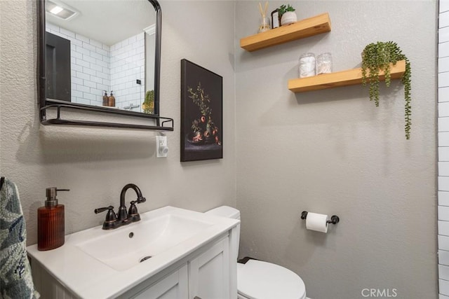 bathroom featuring toilet and vanity