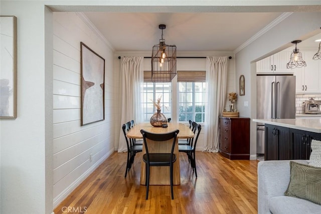 dining area featuring light wood-type flooring and ornamental molding