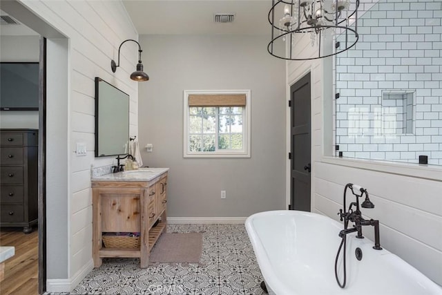 bathroom featuring a tub to relax in, vanity, tile patterned flooring, and an inviting chandelier