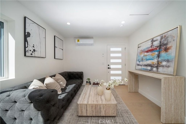 living room featuring light hardwood / wood-style flooring and a wall unit AC