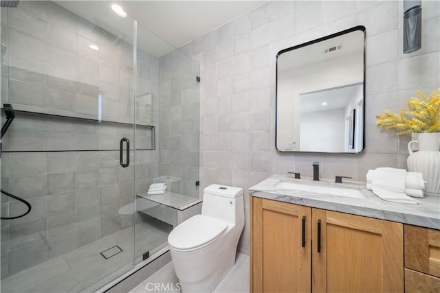 bathroom with vanity, tasteful backsplash, tile walls, toilet, and walk in shower