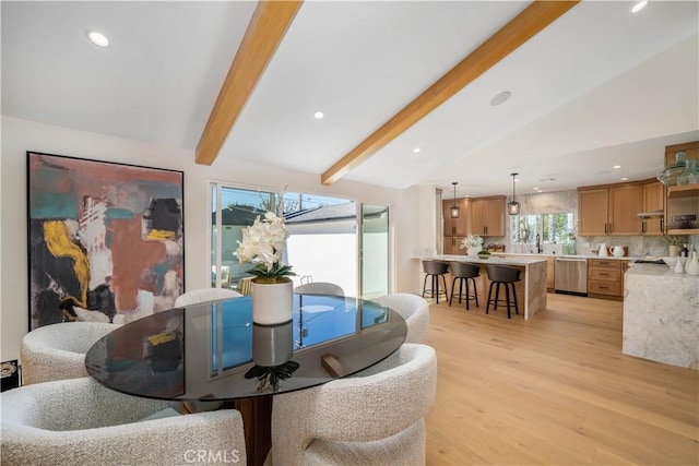 dining area with light hardwood / wood-style flooring and lofted ceiling with beams