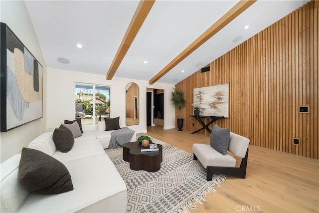 living room with lofted ceiling with beams, wooden walls, and wood-type flooring