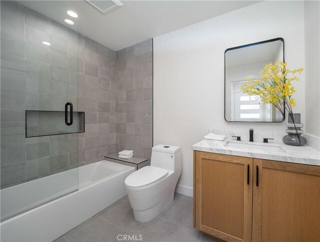 full bathroom featuring toilet, vanity, tile patterned flooring, and combined bath / shower with glass door