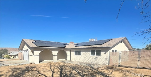 view of front facade featuring a garage and solar panels