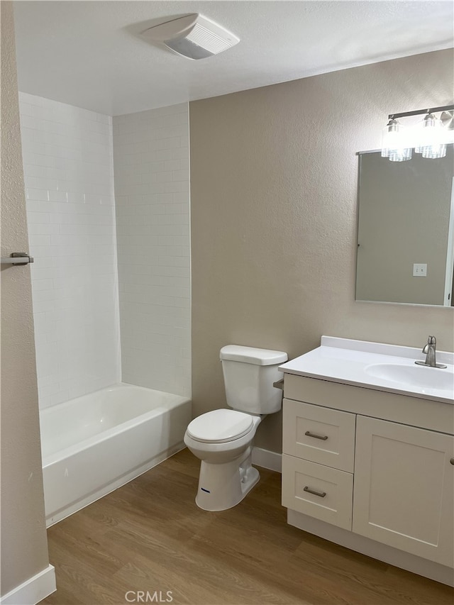 full bathroom with shower / tub combination, vanity, hardwood / wood-style floors, and toilet