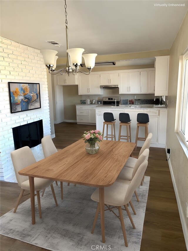 dining area with dark hardwood / wood-style floors and a notable chandelier