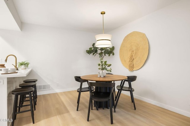 dining room with light hardwood / wood-style floors and sink