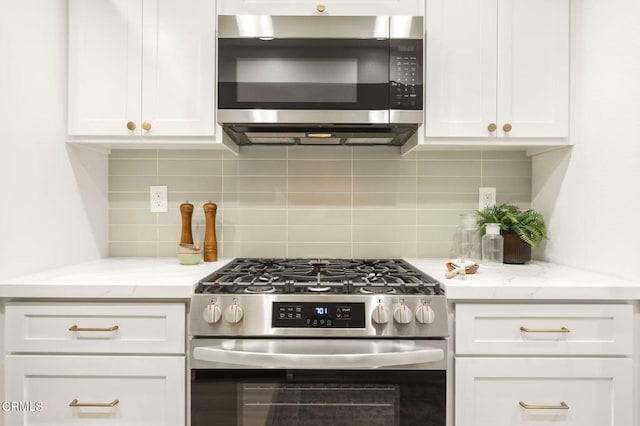 kitchen with white cabinets, backsplash, and stainless steel appliances