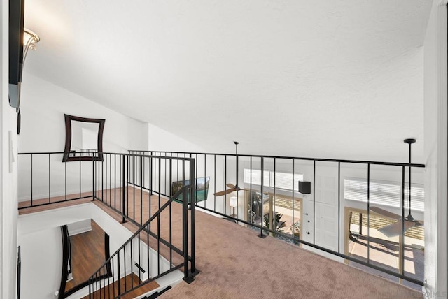 hallway featuring carpet and vaulted ceiling