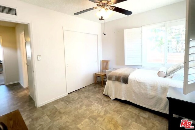 bedroom featuring ceiling fan and a closet